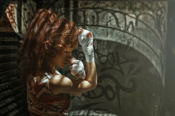 The boxer is a fiery redhead with her hands in bandages