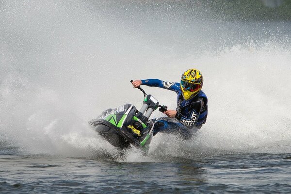 Atleta con casco giallo che corre su una moto d acqua