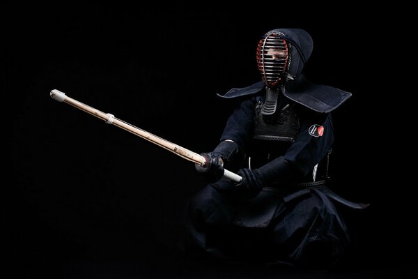 A kendo fighter in a black uniform is ready to meet an opponent