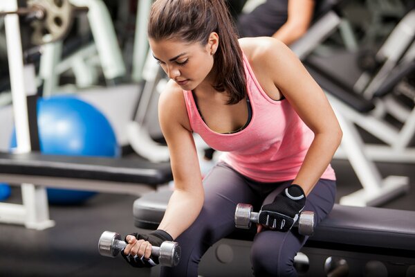 A woman in the gym with dumbbells