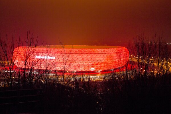 Stade lumineux dans la nuit. Rétro-éclairage rouge