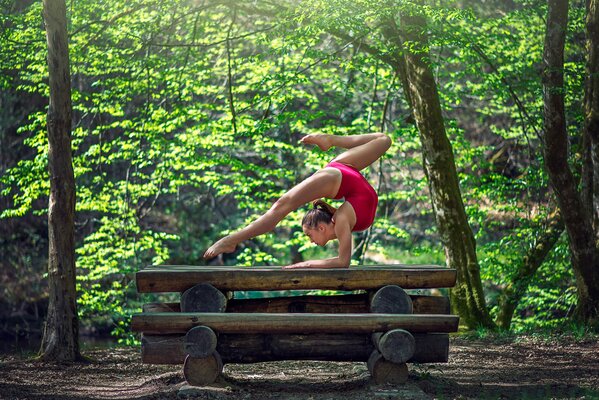 Turnerin in Pose im dumpfen Wald