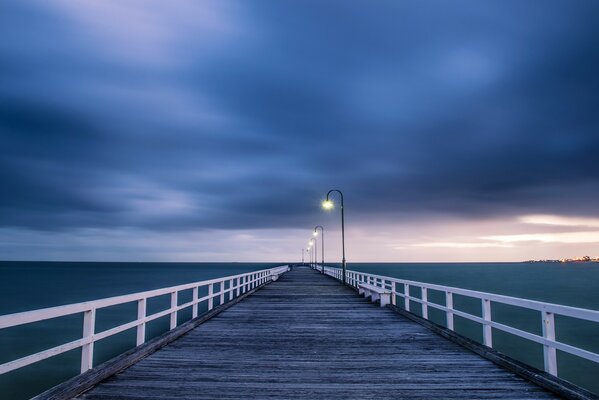 Puente de madera iluminado por linternas