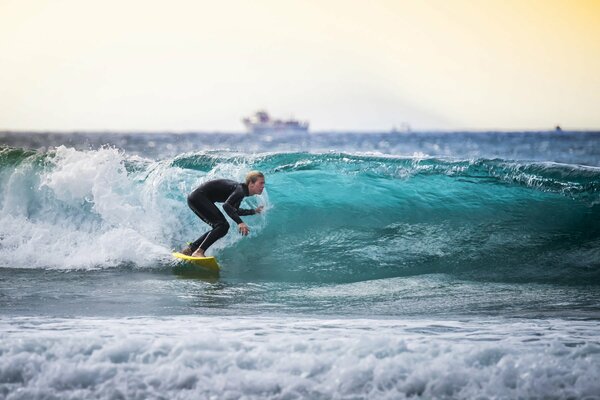 Ein Surfer und ein Schiff am Horizont