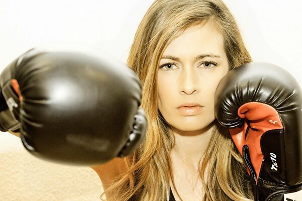 Rubia en guantes de boxeo golpea a la derecha