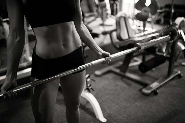 Woman hold a barbell in the gym