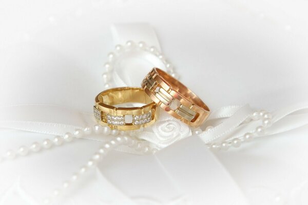 Wedding rings on a white background with pearls