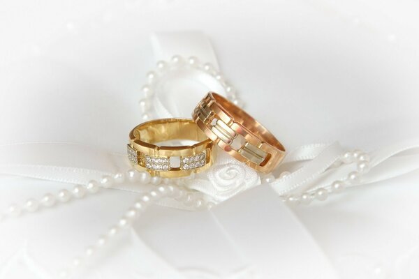 Anneaux de mariage sur fond blanc avec des perles