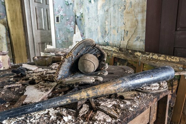 Batte de baseball, gant et balle dans une maison détruite