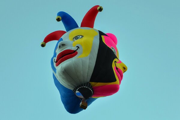Яркий воздушный шар в виде клоуна на голубом фоне