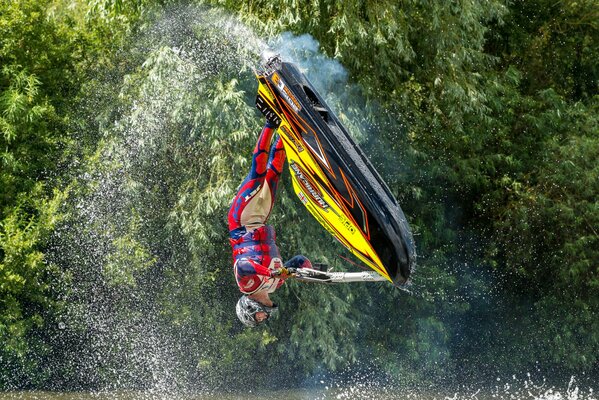 Sprung auf einem Roller auf dem Wasser mit Spritzwasser