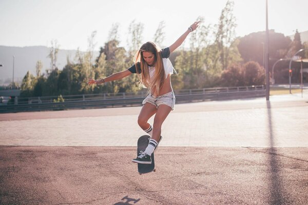 Schöne sportliche Mädchen auf einem Skateboard