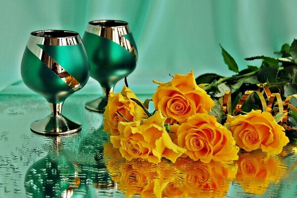 Belles roses avec des verres sur la table