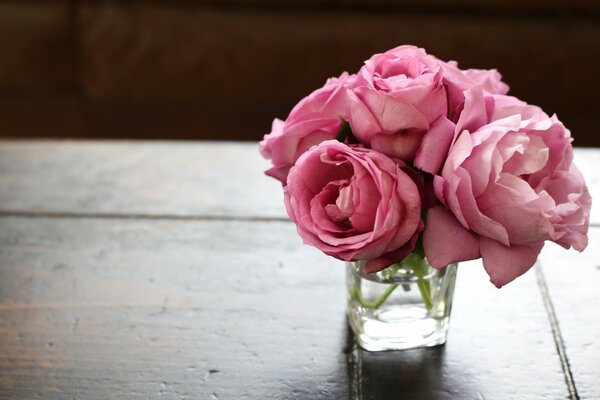 Un ramo de rosas en un jarrón sobre una mesa