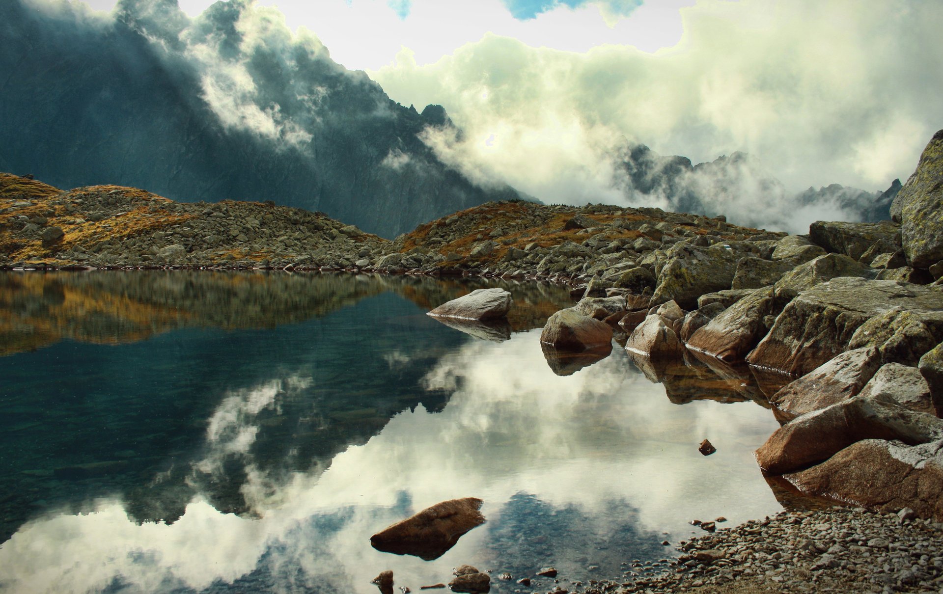 lake reflection stones rocks fog clouds mountain