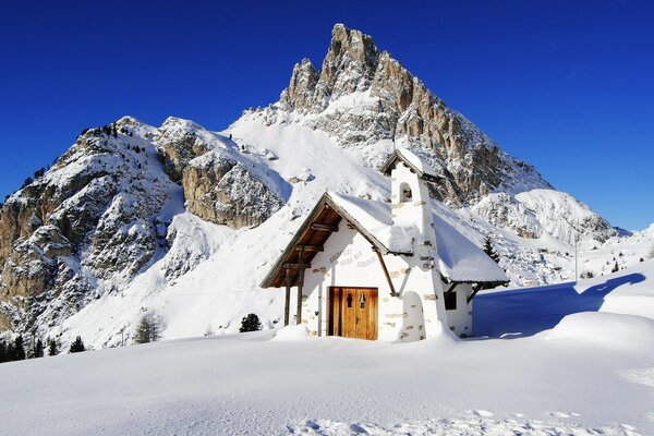 Sulla montagna c è una casa in cumuli di neve. Inverno in montagna