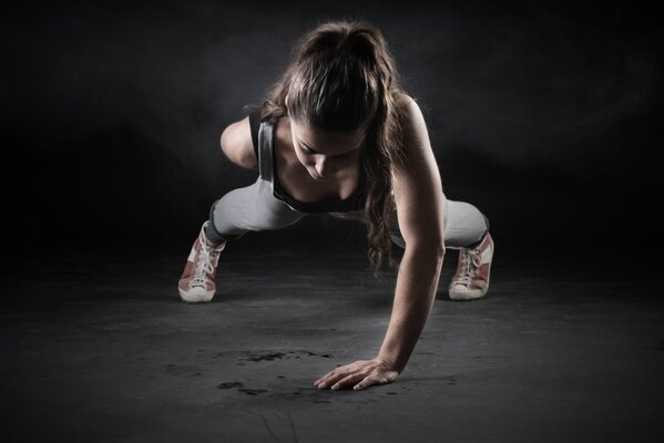 Fille de sport avec les cheveux retroussés est pressée sur une main