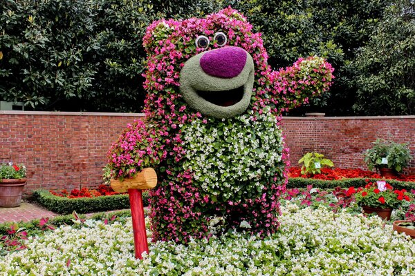 Sculpture of a bear made of flowers with a hammer