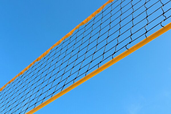 The volleyball net with yellow edging is stretched