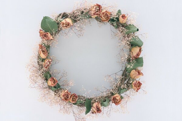 Wreath of roses and leaves on a gray background