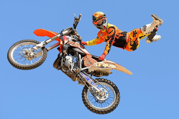 A motorcyclist on a motorcycle is flying in the sky