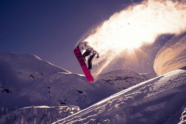 Salta sullo snowboard lungo la pista invernale