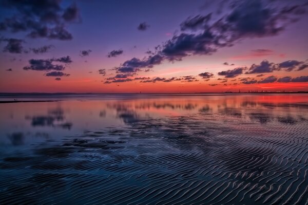 A lake covered with a pink sunset