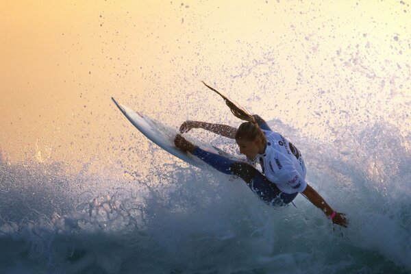 A girl on a snowboard jumps on a wave