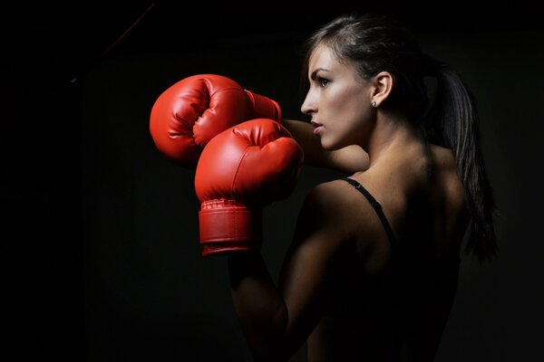 Rote Boxhandschuhe bei einer Frau. Boxen. Defensive Posen