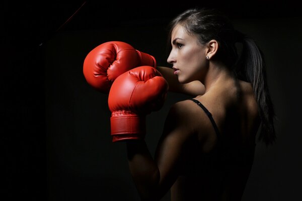 The woman has red boxing gloves. Box. Defensive poses