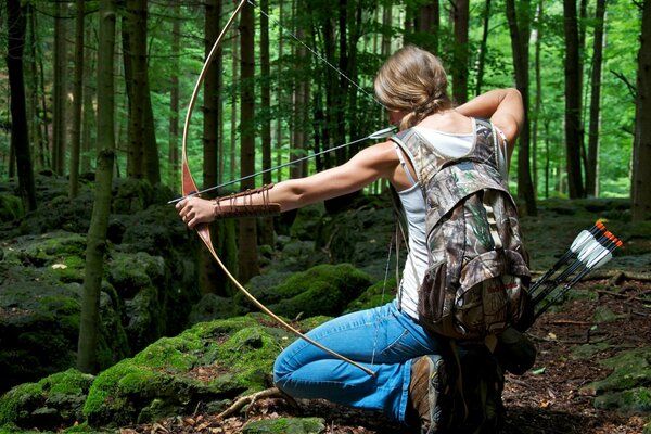 Девушка с луком и стрелами в лесу. Стрельба из лука