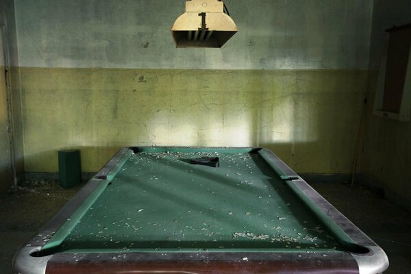 Pièce abandonnée avec de la poussière sur la table de billard