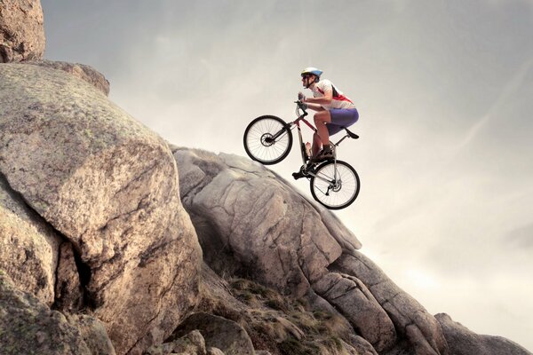 A man on a bicycle rides over rocks