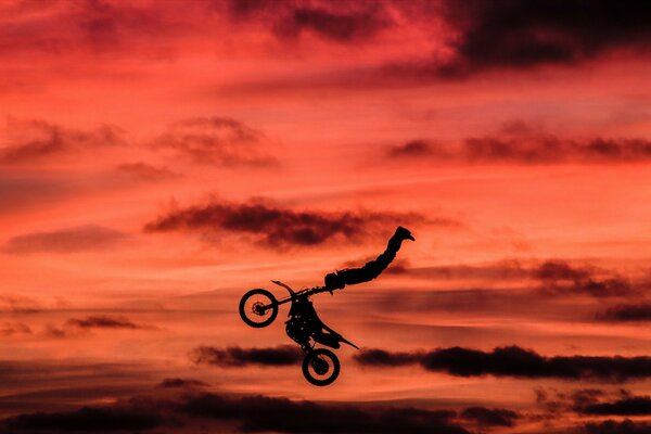 Trucco su uno sfondo di nuvole rosse su una moto