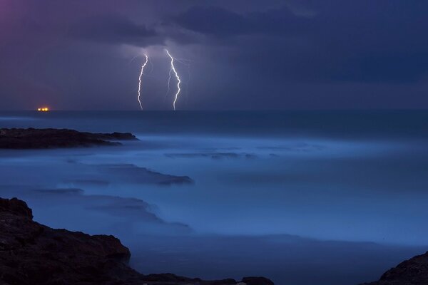 Lightning in the night sky over the water