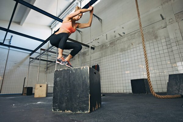 Chica haciendo fitness en el cubo gris