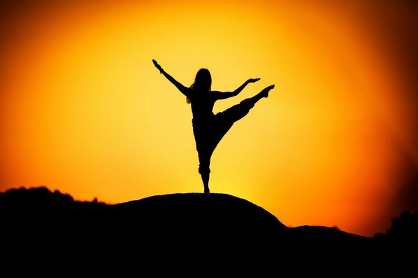 Silhouette of a girl against the background of the sun