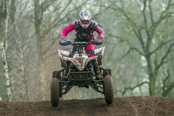 Corsa in quad. Uomo in casco su ATV