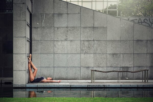 Piernas de gimnasta elegantes en una pared gris