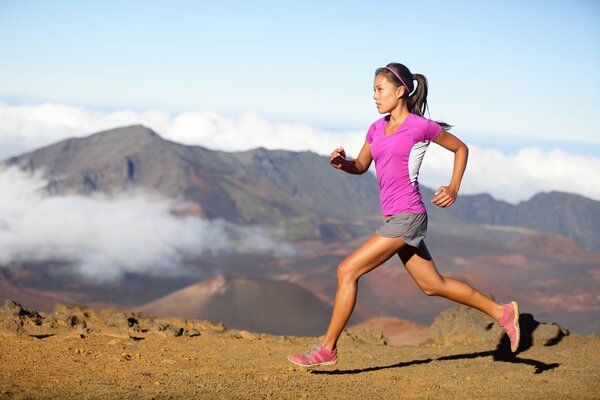 Chica corriendo en el fondo de las montañas