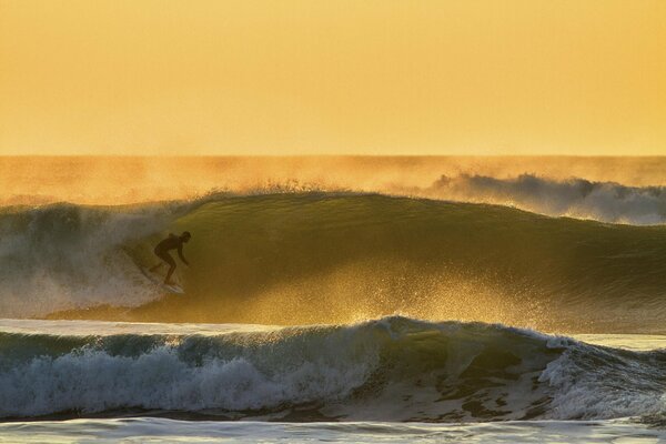 Surfeur sportif effectue des cascades dans la mer