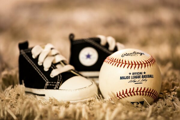 Two sneakers are standing next to the ball