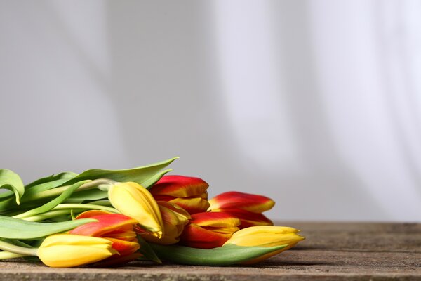 Ramo de tulipanes multicolores en una mesa de madera