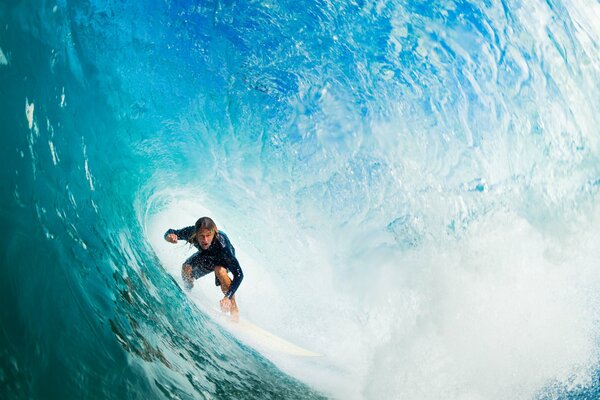 The guy is surfing , conquering the Wave