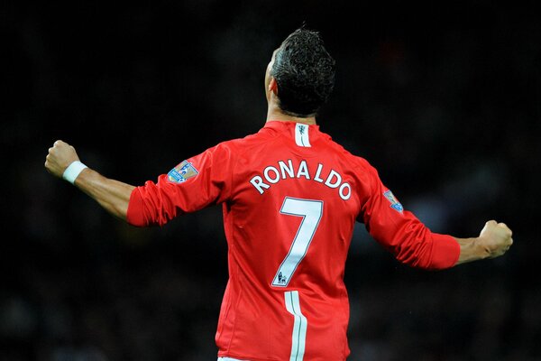 Piłkarz w czerwonej koszulce z numerem siedem cieszy się ze zwycięstwa