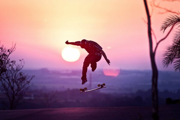 Lo skateboarder ha fatto il salto al tramonto