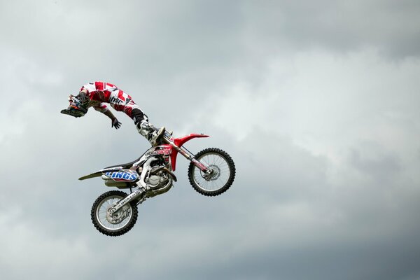 Ein Motorradfahrer führt beim Springen Stunts in der Luft durch