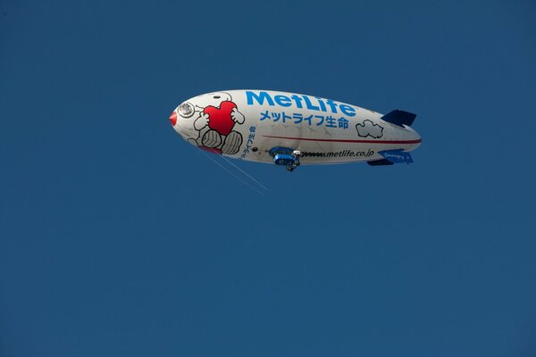 Ballon dirigeable dans le ciel sur fond bleu