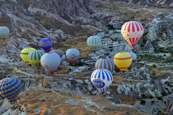 The balloons are very high above the mountain landscape