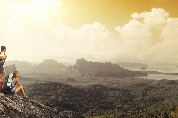 Tourists with backpacks in the mountains admire the clouds